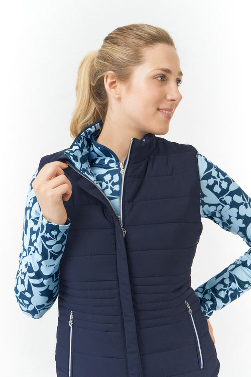 Pure Golf Eve reversible ladies gilet for golf is insulated, winter-weight, patterned and reversible. It has been Insulated for warmth without being bulky. One side features intricate Midnight Rose floral prints in navy and powder blue, while the other offers a classic plain navy option for versatility of wear. It has pockets on both sides and two-way zippers. The flattering quilting style and fit enhances your silhouette.