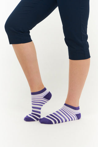 White ladies trainer golf sock, 3 pack with 2 stripped purple pairs and one plain white pair with the word "golf" on the sole, also with a cushioned sole and compression fit. The lower cut around the ankle makes them less visible when worn. Made from a soft, stretchy cotton blend fabric allows breathability. They are suited to UK sizes between 4 and 7. 85% Cotton, 13% Polyester, 2% Elastane.