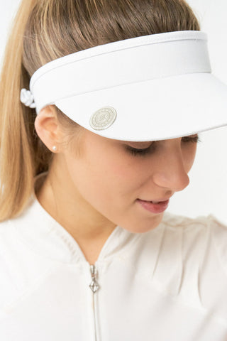 White ladies golf visor constructed with quick-drying fabrics. The visor comes in a one size fits all design with an elasticated cord at the rear to hold it securely in place. It also features a concealed magnet  in peak with a hand enamelled lace golf ball marker attached, making it a lovely golf accessory, golf gift! The headband features a soft lined absorbent towel. 