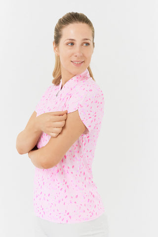 The Pure Golf Rise cap sleeve ladies' golf polo shirt in Soft Sakura, featured in a side model shot, showcases the beautiful sleeve. The Print is an array of lilac, pink, and white petals against a light pink backdrop. Designed with a regular fit, it provides 4-way stretch for a flattering shape on all body types. The mandarin collar adds a touch of elegance. Made from 95% Polyester and 5% Spandex, the shirt offers anti-crease, anti-static, and quick-dry properties, along with UPF 50+ sun protection. 