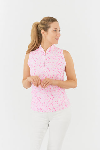 The Pure Golf rise sleeveless ladies' golf polo shirt in Soft Sakura model  shot showcases a subtle print of lilac, pink and white petals on a light pink backdrop. Designed with a regular fit, it offers a 4-way stretch for comfort and a flattering shape on all body types. The mandarin collar offers adds a touch of elegance. Made from 95% Polyester and 5% Spandex, offering anti-crease, anti-static, and quick-dry properties, along with UPF 50+ sun protection. Paired with White Bermuda Shorts.